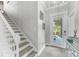 Bright foyer featuring stairs, a glass-paneled door, and tile flooring, creating a welcoming entrance at 6518 Salt Creek Ave, Apollo Beach, FL 33572
