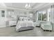 Elegant main bedroom with a tray ceiling, large windows, and sitting chairs at 6518 Salt Creek Ave, Apollo Beach, FL 33572