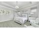 Bright main bedroom featuring an elegant light fixture, stylish décor, and sitting chairs at 6518 Salt Creek Ave, Apollo Beach, FL 33572