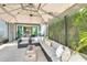 Comfortable seating area with an umbrella provides a relaxing space in this screened patio at 6518 Salt Creek Ave, Apollo Beach, FL 33572