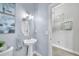 Cozy powder room featuring a pedestal sink, modern lighting, and tasteful decorations for guests' convenience at 6518 Salt Creek Ave, Apollo Beach, FL 33572