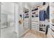 Custom walk-in closet with built-in shelves and drawers, plus a view to the ensuite bathroom at 6518 Salt Creek Ave, Apollo Beach, FL 33572