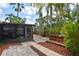 Backyard with a screened-in patio, lush tropical landscaping, and a bridge at 7020 Oakview Cir, Tampa, FL 33634
