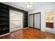 Bedroom with built-in shelving, wood floors, and an ensuite bathroom at 7020 Oakview Cir, Tampa, FL 33634