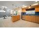 Open kitchen featuring wooden cabinets, stainless steel appliances, tiled floors and a breakfast bar at 7020 Oakview Cir, Tampa, FL 33634