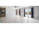 Open-concept living room with tile floors, ceiling fan, and French doors to the backyard at 7020 Oakview Cir, Tampa, FL 33634