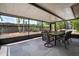 Screened patio with dining table, chairs, and textured concrete flooring overlooking the backyard at 7020 Oakview Cir, Tampa, FL 33634
