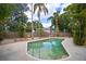 Swimming pool area surrounded by concrete and tropical foliage with partial fence at 7020 Oakview Cir, Tampa, FL 33634
