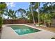 Backyard view of an in-ground pool surrounded by a concrete patio and wooden fence at 7020 Oakview Cir, Tampa, FL 33634