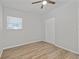 Neutral bedroom featuring wood-look floors, a ceiling fan, closet and a window at 7139 Adare Dr, New Port Richey, FL 34653