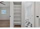 Hallway storage and bathroom entrance featuring built-in shelving for linens and bathroom necessities at 7139 Adare Dr, New Port Richey, FL 34653
