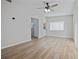Bright living room with hardwood floors, a modern ceiling fan, and large windows at 7139 Adare Dr, New Port Richey, FL 34653