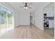 Open-concept living room featuring hardwood floors, a ceiling fan, and ample natural light at 7139 Adare Dr, New Port Richey, FL 34653