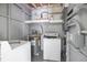 Utility room featuring a water heater, washer, and some storage space on the shelves at 7139 Adare Dr, New Port Richey, FL 34653