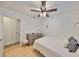 This bedroom features a ceiling fan, hardwood floors, and a view into an adjacent bathroom at 7491 Cedar Ne St, St Petersburg, FL 33702