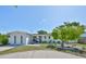 Charming one story home featuring a lush green lawn, tasteful landscaping, and a painted white brick facade at 7491 Cedar Ne St, St Petersburg, FL 33702