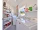 Functional laundry room featuring modern washer and dryer, storage shelves, and natural light from the window at 7491 Cedar Ne St, St Petersburg, FL 33702