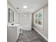 Clean bathroom featuring white fixtures, modern flooring, and a well-lit vanity area at 8215 N 12Th St, Tampa, FL 33604
