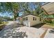 Quaint white home with a long driveway and lush trees in the background at 8215 N 12Th St, Tampa, FL 33604