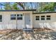 The home's entrance features a screen door, steps, and exterior lighting at 8215 N 12Th St, Tampa, FL 33604