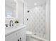Modern bathroom with designer tile shower, black fixtures and stylish vanity at 8409 Lantana Dr, Seminole, FL 33777