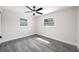 Neutral bedroom with wood-look flooring, ceiling fan, and bright windows at 8409 Lantana Dr, Seminole, FL 33777