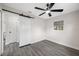 Bedroom featuring modern sliding closet door, ceiling fan and gray wood floors at 8409 Lantana Dr, Seminole, FL 33777