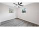 Bright bedroom with two windows, gray flooring, and neutral paint at 8409 Lantana Dr, Seminole, FL 33777