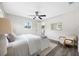 Bright bedroom with modern ceiling fan, gray wood flooring, and a comfy chair at 8409 Lantana Dr, Seminole, FL 33777