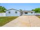 Exterior of house featuring a large driveway and new paint at 8409 Lantana Dr, Seminole, FL 33777