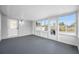Light filled Florida room with gray floors, white walls, and back yard access at 8409 Lantana Dr, Seminole, FL 33777