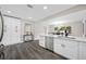 Modern kitchen with white cabinets, stainless steel appliances, and a view of the dining area at 8409 Lantana Dr, Seminole, FL 33777