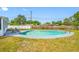 Backyard with an in-ground pool, green grass, and a privacy fence at 8409 Lantana Dr, Seminole, FL 33777