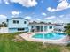 Backyard view of the light blue home with a pool, patio, green grass, and sunny skies above at 8722 Hickorywood Ln, Tampa, FL 33615