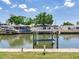 Waterfront view of a boat lift and canal access, with serene water and clear skies at 8722 Hickorywood Ln, Tampa, FL 33615