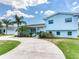 Charming light blue two-story home with lush tropical landscaping and a spacious driveway at 8722 Hickorywood Ln, Tampa, FL 33615