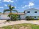 Charming light blue two-story home with lush tropical landscaping and a spacious circular driveway at 8722 Hickorywood Ln, Tampa, FL 33615