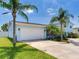 Charming light blue two-story home with lush tropical landscaping, two car garage, and spacious driveway at 8722 Hickorywood Ln, Tampa, FL 33615