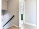 View of a downstairs hallway with wood floor, leading to a bathroom featuring a dark green vanity at 8722 Hickorywood Ln, Tampa, FL 33615