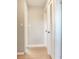 Neutral hallway with light hardwood floors, white doors, and white trim at 8722 Hickorywood Ln, Tampa, FL 33615