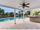 Covered brick patio overlooking a private pool and canal, featuring a ceiling fan for added comfort at 8722 Hickorywood Ln, Tampa, FL 33615