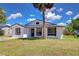 Inviting single-story home featuring a well-kept lawn and a mature tree enhancing its curb appeal at 911 Kirkcaldy Way, Valrico, FL 33594