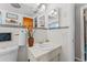 Well-lit bathroom featuring a sink vanity, toilet, decorative mirror and fixtures at 3748 Redwood Dr, Holiday, FL 34691