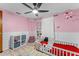 Cheerful pink bedroom with ceiling fan, furniture and play area at 3748 Redwood Dr, Holiday, FL 34691