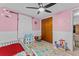 Cheerful pink bedroom with ceiling fan, closet, and play area at 3748 Redwood Dr, Holiday, FL 34691