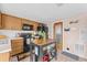 Bright kitchen features wood cabinets, black appliances, a kitchen island and an exterior access door at 3748 Redwood Dr, Holiday, FL 34691