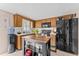 Bright kitchen features wood cabinets, black appliances, a kitchen island, and light-colored countertops at 3748 Redwood Dr, Holiday, FL 34691