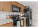 Bright kitchen features wood cabinets, black appliances, and light-colored countertops at 3748 Redwood Dr, Holiday, FL 34691