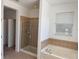 Bathroom featuring glass shower, bathtub with tile surround, and a bright window at 11318 Laurel Brook Ct, Riverview, FL 33569