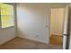 Bedroom with neutral carpet, white walls, window and a door that leads outside at 11318 Laurel Brook Ct, Riverview, FL 33569